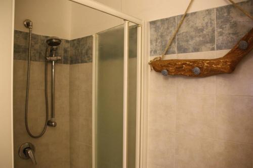 a bathroom with a shower with a log on the wall at Sotto la Rocca in Angera