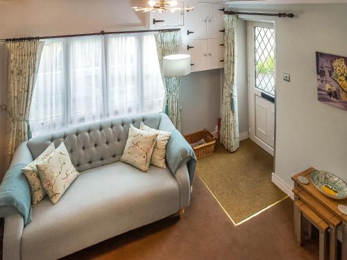 a living room with a couch and some windows at Apple Blossom Cottage - Uk46648 in Cheddar