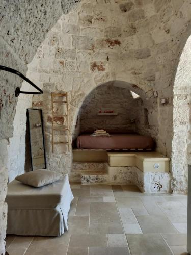 a bedroom with a bed in a stone wall at Trullo del Sol in Ceglie Messapica