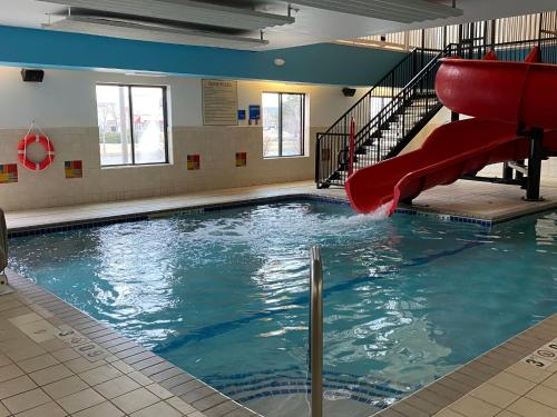 a swimming pool with a red slide in a building at Holiday Inn Express Hotel & Suites Loveland by IHG in Loveland