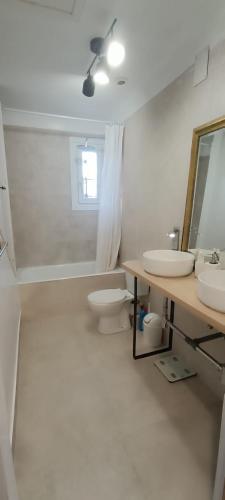 une salle de bain avec deux lavabos et un WC et un miroir dans l'établissement Maison de ville avec grande terrasse à Caneta, à Hendaye