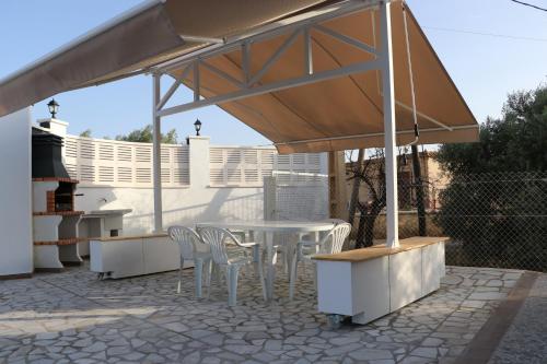a patio with a table and chairs under a canopy at Villa Calatrue - Tabernas in Tabernas