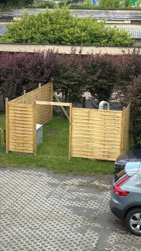 a wooden fence in the grass next to a car at Alinas Ferienwohnung Güstrow in Güstrow