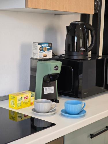 a coffee maker and cups on a kitchen counter at Ermanno s Home 5terre stazione centro città in La Spezia