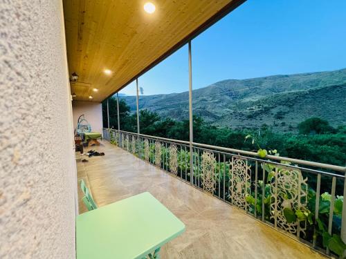 a balcony with a table and a view at Guesthouse Mtkvari in Nak'alak'evi