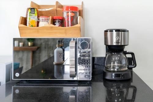 a microwave sitting on a counter next to a coffee maker at Luxe Modern-5 Star Area-Walk 2 Beach-Pool-BBQ-View-King Bed in Mazatlán