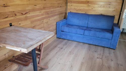 un sofá azul y una mesa en una habitación en Magnifique roulotte, en Sospel