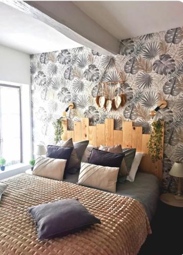 - une chambre avec un grand lit et du papier peint tropical dans l'établissement Ô p'tit 44 Apt + terrasse dans le vieux Honfleur, à Honfleur