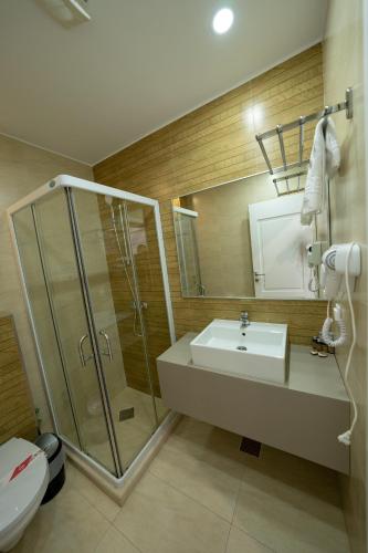 a bathroom with a sink and a shower and a toilet at Pensiunea Blue House in Murighiol