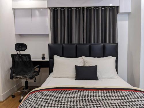 达卡Minimalist Apt at DAC Intl Airport Msg to Avail Special Offer for Flight Catcher的一间卧室配有一张带椅子的床和一张书桌