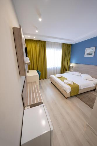 a bedroom with a large bed and a blue wall at Pensiunea Blue House in Murighiol