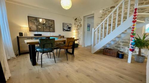 une salle à manger avec une table et un escalier dans l'établissement Ty Leroux - wifi - centre bourg, à Crozon