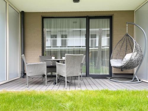 a patio with a table and chairs and a swing at Apartamenty Florina Q4Apartments in Łeba