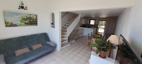 un salon avec un canapé vert et une cuisine dans l'établissement DUPLEX T2 vue mer avec le patio et l'arrivée autonome, à La Celle-sous-Gouzon