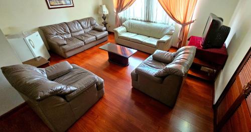 a living room with two couches and a tv at Hotel Santa Isabel 2 in Ipiales
