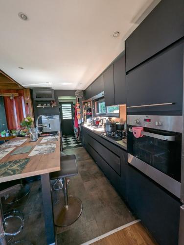 a kitchen with black cabinets and a wooden table at Case entre2containers in LʼEntre-Deux