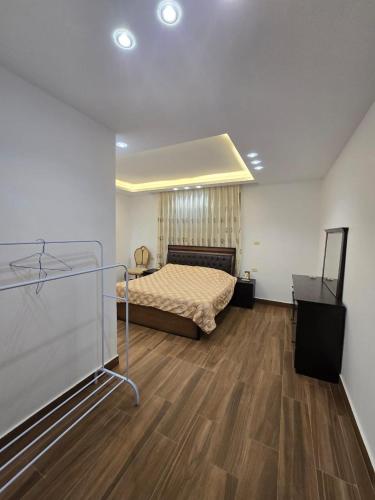 une chambre avec un lit et un parquet dans l'établissement Le Jardin, à Madaba