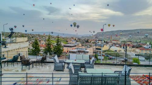 a group of balloons flying in the sky over a city at Gala Cave Cappadocia in Goreme