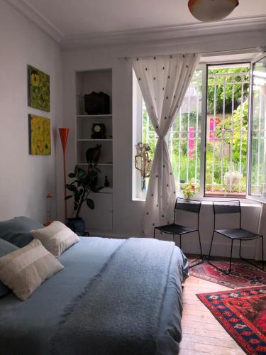 une chambre avec un grand lit et une fenêtre dans l'établissement Noctuelle, à Bourges