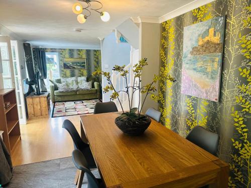 a dining room with a wooden table and chairs at Bay View Cottage in St Austell