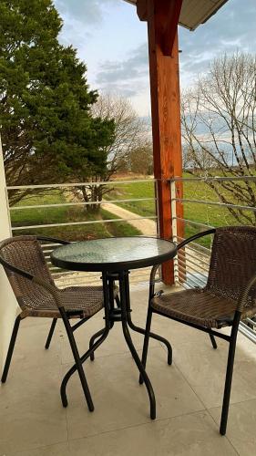 - une table et deux chaises sur une terrasse couverte avec une table et des chaises dans l'établissement Havre de paix - Campagne Gasconne - T3 neuf - 120m2, à Sainte-Maure-de-Peyriac