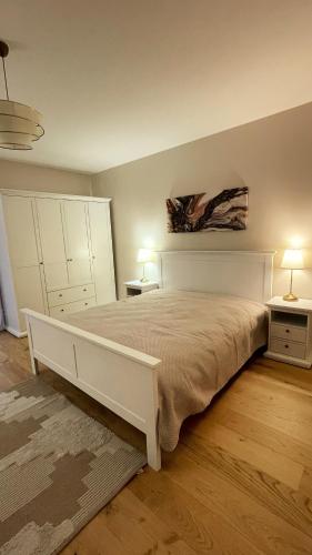 une chambre avec un grand lit blanc et deux lampes dans l'établissement Havre de paix - Campagne Gasconne - T3 neuf - 120m2, à Sainte-Maure-de-Peyriac