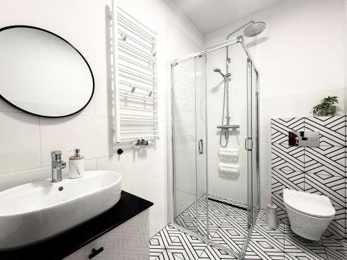 a bathroom with a sink and a shower at Apartamenty Florina Q4Apartments in Łeba