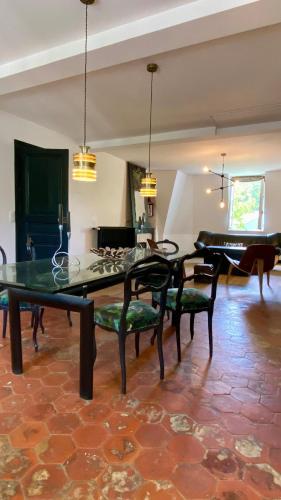 Cette chambre comprend une table, des chaises et un piano. dans l'établissement Unique 4 bedroom topfloor flat in a XIX century Mansion in Western Paris, à Ville-dʼAvray