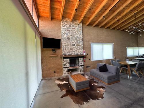 ein Wohnzimmer mit einer Couch, einem Fernseher und einem Tisch in der Unterkunft Colmar 48 Cabin in Tapalpa