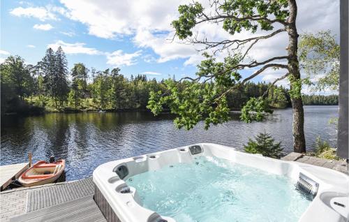 a bath tub sitting on a deck next to a river at Amazing Home In Borås With Wifi in Borås
