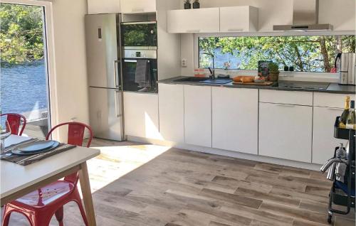 a kitchen with white cabinets and a table with chairs at Amazing Home In Borås With Wifi in Borås