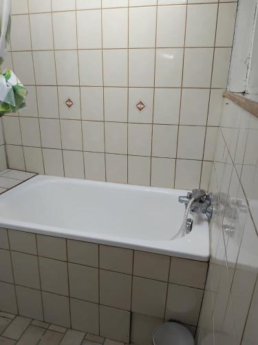 une salle de bain avec une baignoire blanche et un lavabo dans l'établissement Logement atypique, à Saint-Mesmin
