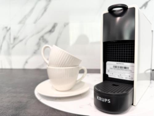 a coffee maker and a cup on a table at Apartamenty Florina Q4Apartments in Łeba