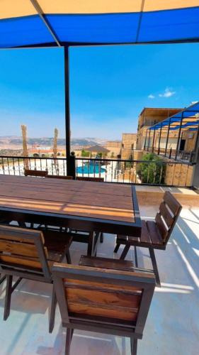 a picnic table and chairs on a roof with a view at Al Eman Oasis Farm in Jal‘ad