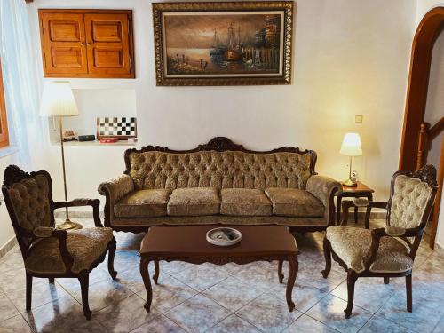 a living room with a couch and two chairs at Margo Traditional House in Symi