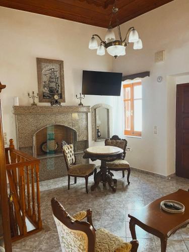 a living room with a table and a fireplace at Margo Traditional House in Symi
