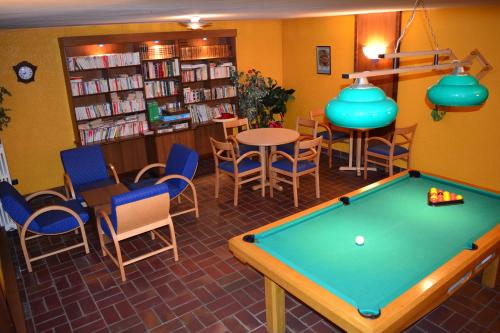 a library with a pool table and chairs at Aiguille Noire in Valloire