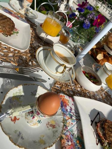 una mesa con platos de comida y una taza de café en L'Inattendue - Chambre Cosy à 150m de la plage, en La Bernerie-en-Retz