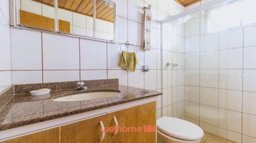 a bathroom with a sink and a toilet at Casa de campo em Atibaia com Lareira e Piscina in Atibaia