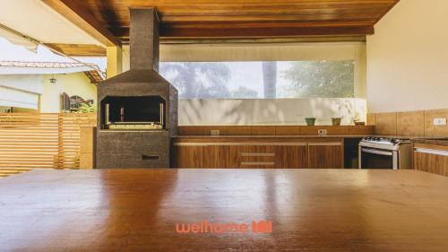 a kitchen with a wooden table with a stove at Casa de campo em Atibaia com Lareira e Piscina in Atibaia