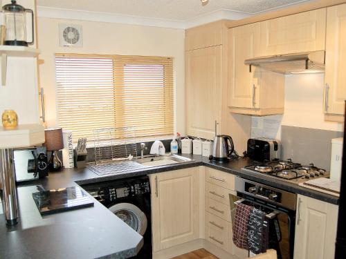 a kitchen with a sink and a dishwasher at Rosewater Lodge in Saint Teath