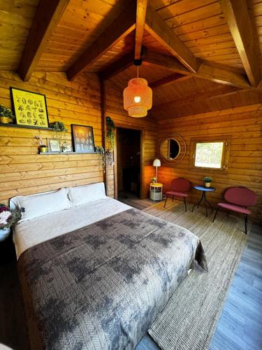 a bedroom with a large bed in a wooden room at The Bungalow - Quinta da BellaVista in Almoster
