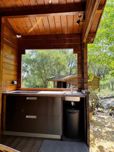 an outdoor kitchen with a sink and a window at The Bungalow - Quinta da BellaVista in Almoster