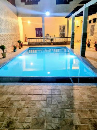 a large swimming pool with blue water in a building at Chalet Panorama in Ouaouizaght