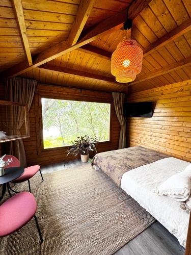 a bedroom with a bed and a large window at The Bungalow - Quinta da BellaVista in Almoster