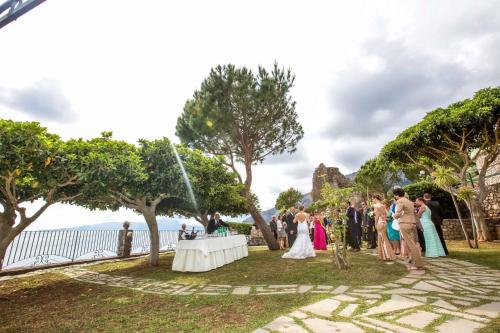 a group of people standing around a table at a wedding at Hotel Club San Diego in Maratea