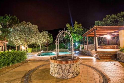 a fountain in front of a pool at night at Hotel Club San Diego in Maratea