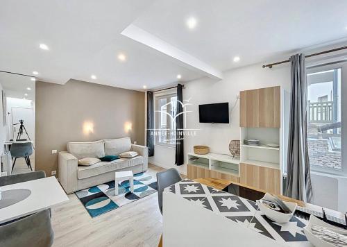 un salon avec un canapé et une télévision dans l'établissement Hyper centre! Magnifique studio à proximité directe de la gare et place morny, à Deauville