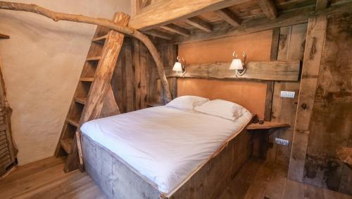 a bedroom with a bed in a wooden room at Au Charme de Rachamps - 4 personnes in Bastogne