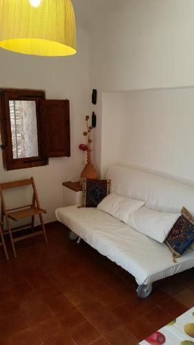 a living room with a white couch and a chair at I Dammusi di Pippo in Lampedusa